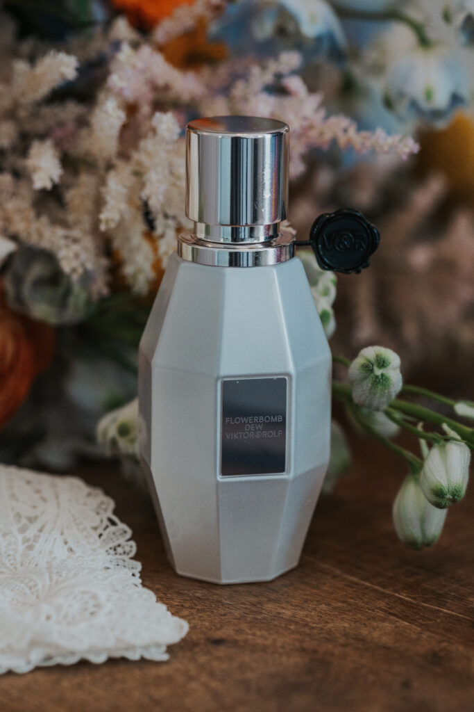 brides perfume bottle next to wedding bouquet