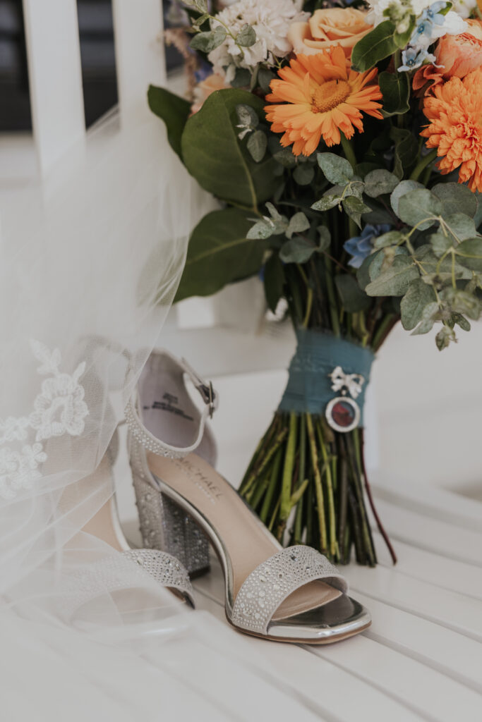 brides wedding bouquet, shoes, and veil on a chair