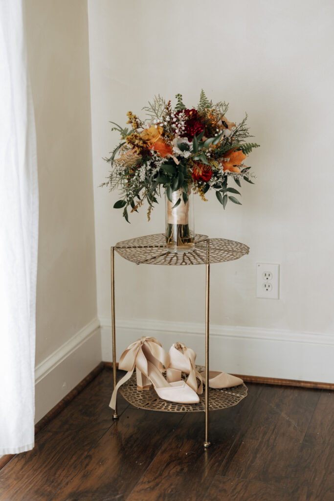 brides wedding bouquet and shoes on a table