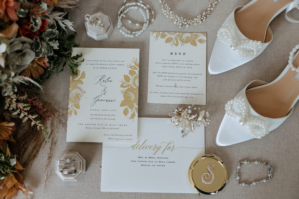 wedding invitations and wedding jewelry laid out on a mat
