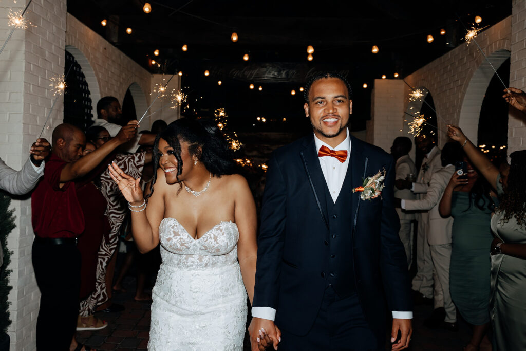 bride and groom leaving their reception through a sparkler tunnel