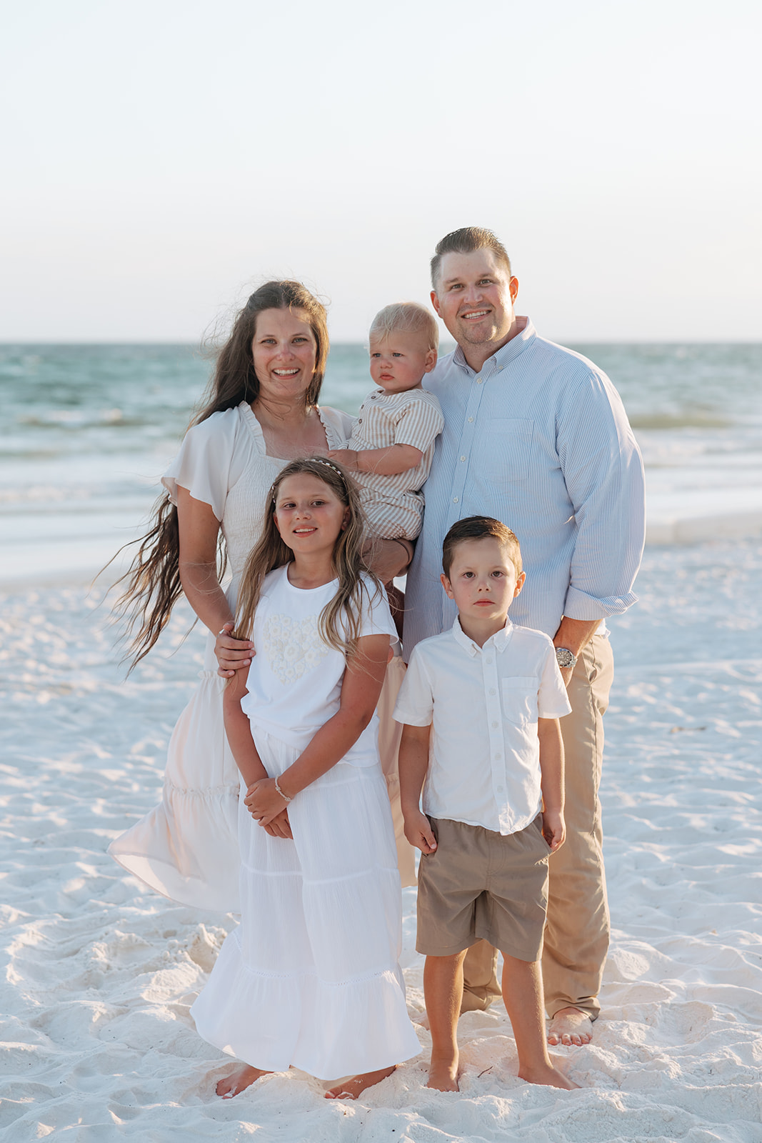 beautiful family pose together on a beach during their family vacation