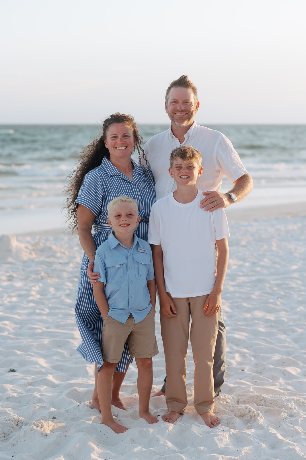 beautiful family pose together on a beach during their family vacation