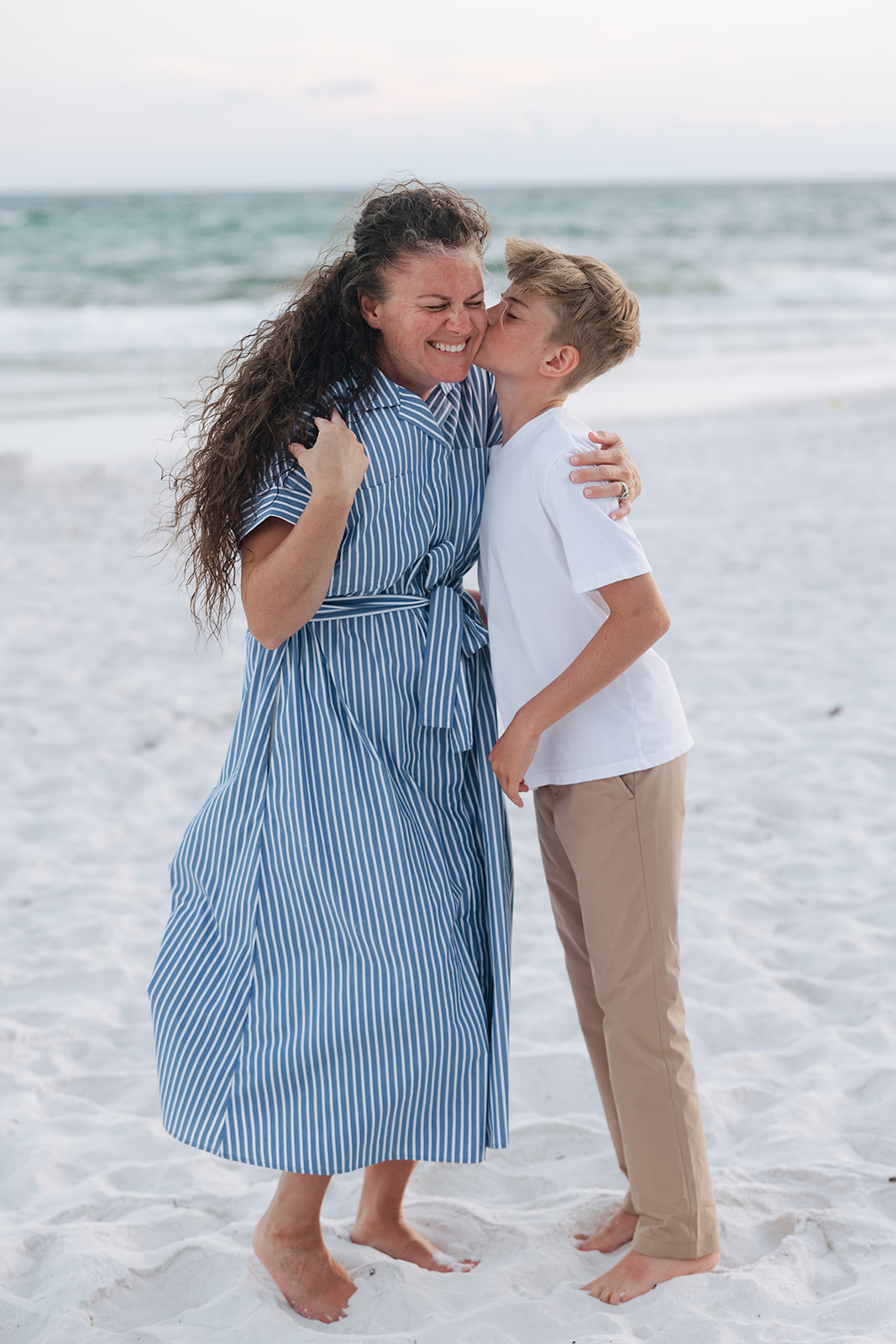 mom and son pose together on the beach