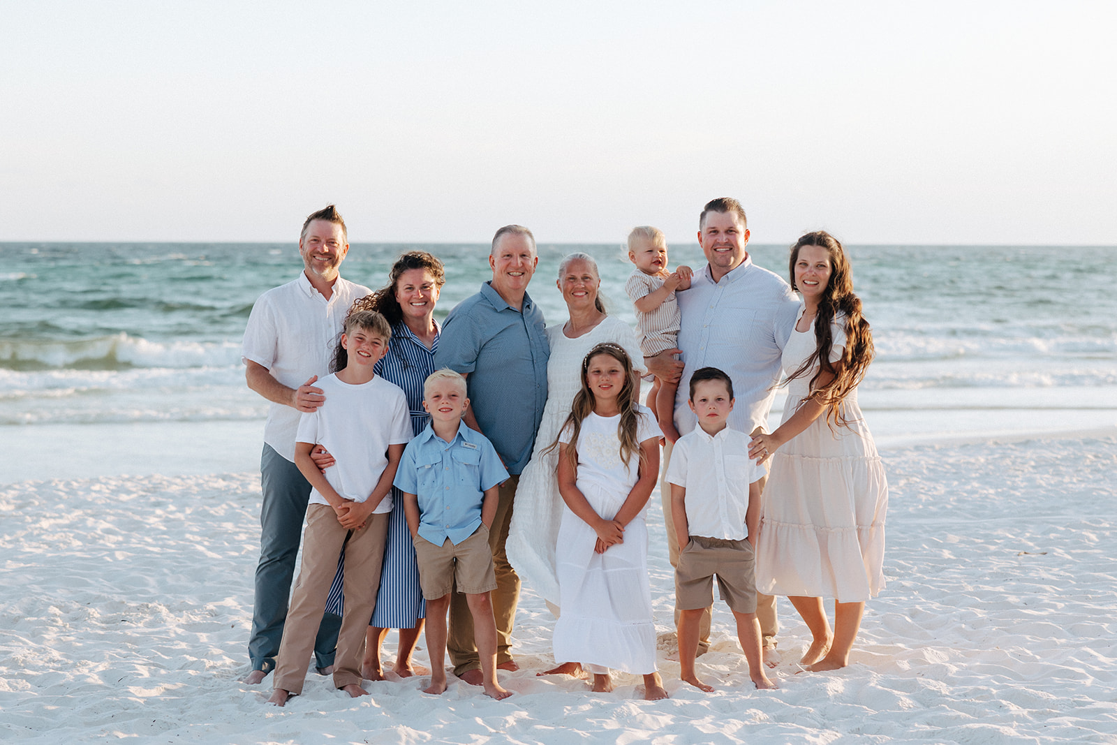 family poses for a beach photo during a family session 