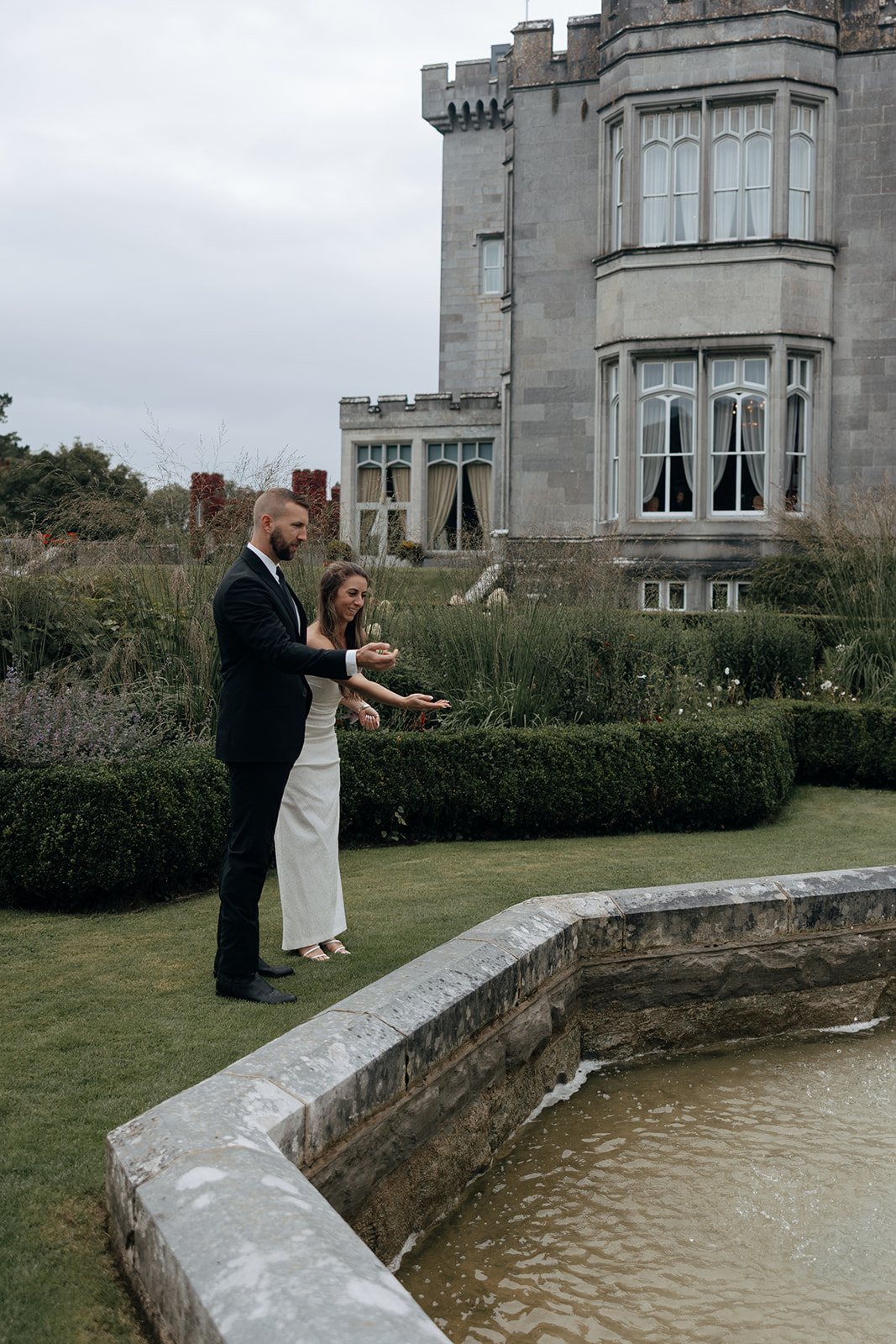stunning couple toss coins in the wishing well