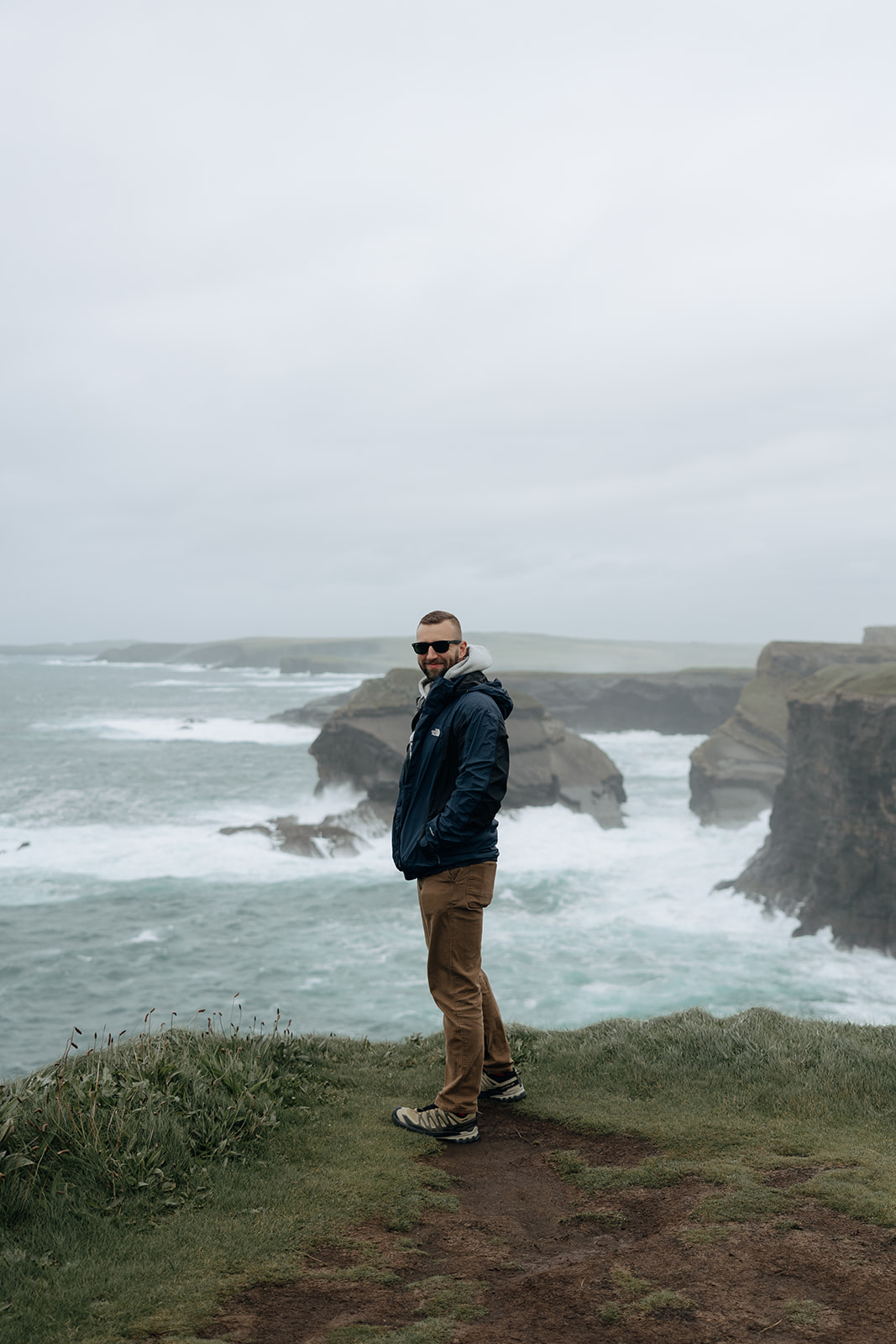 handsome groom poses for a photo on the Kilkee cliffs