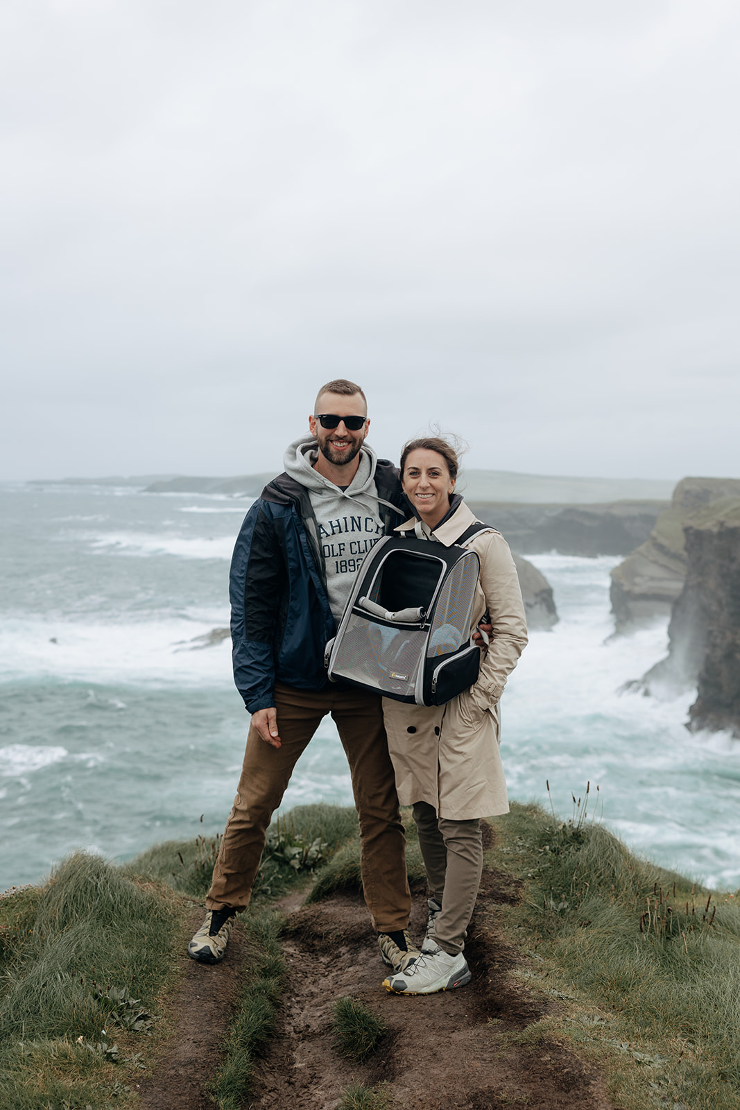 couple pose for a photo on the Kilkee Cliffs with their adventure cat!