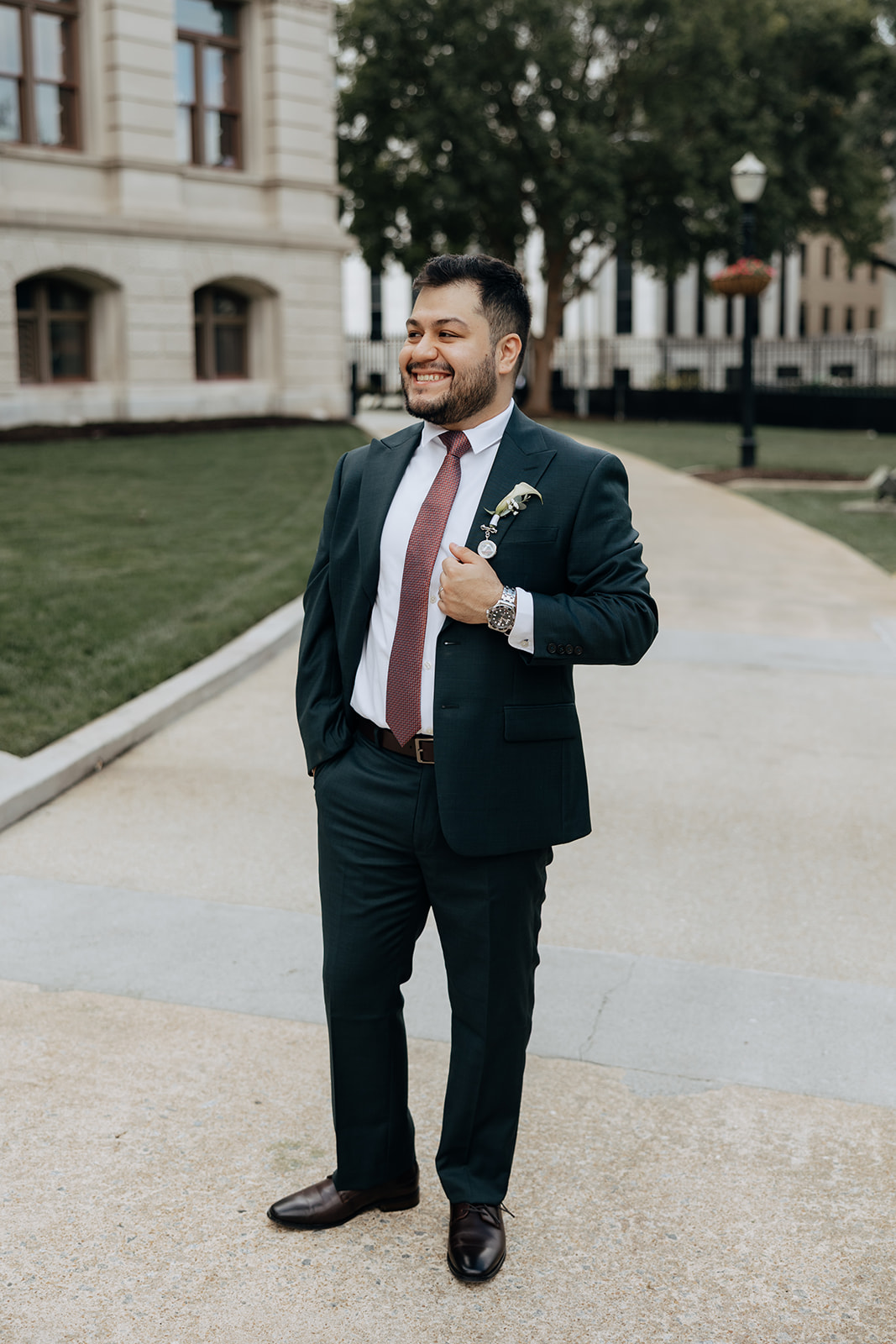 handsome groom poses for a photo outside during his elopement day