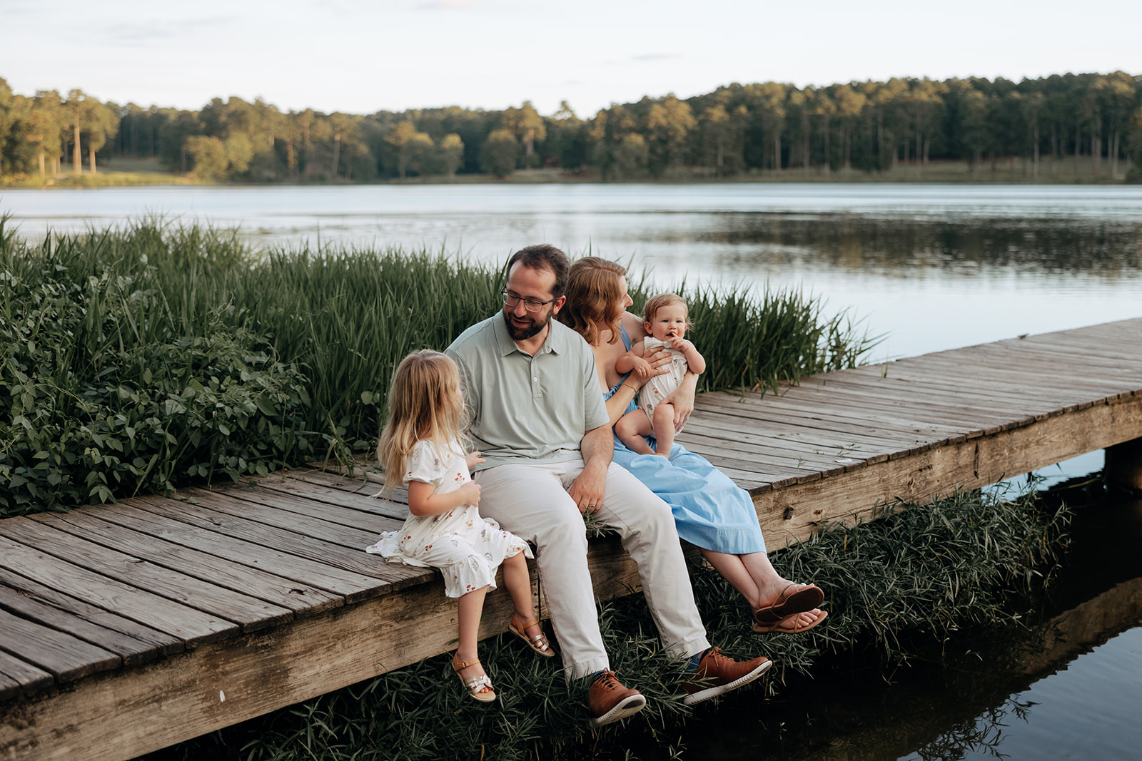 beautiful family walks on a dock during their creative family photoshoot