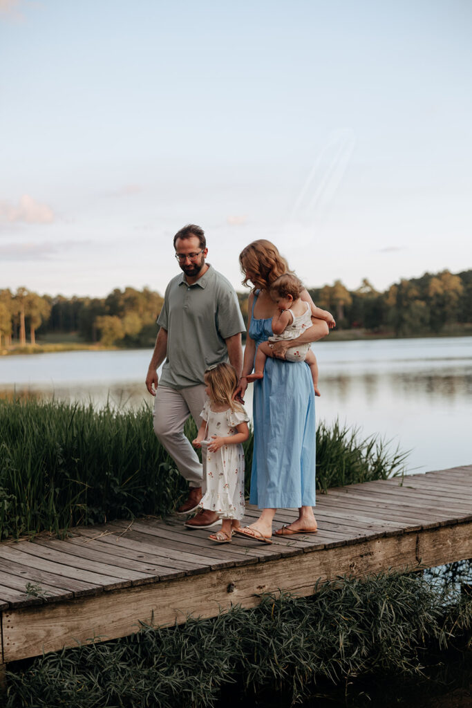 beautiful family walks on a dock during their creative family photoshoot