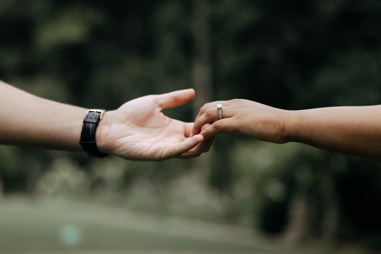 couple reach their hands together during their engagement session in Georgia