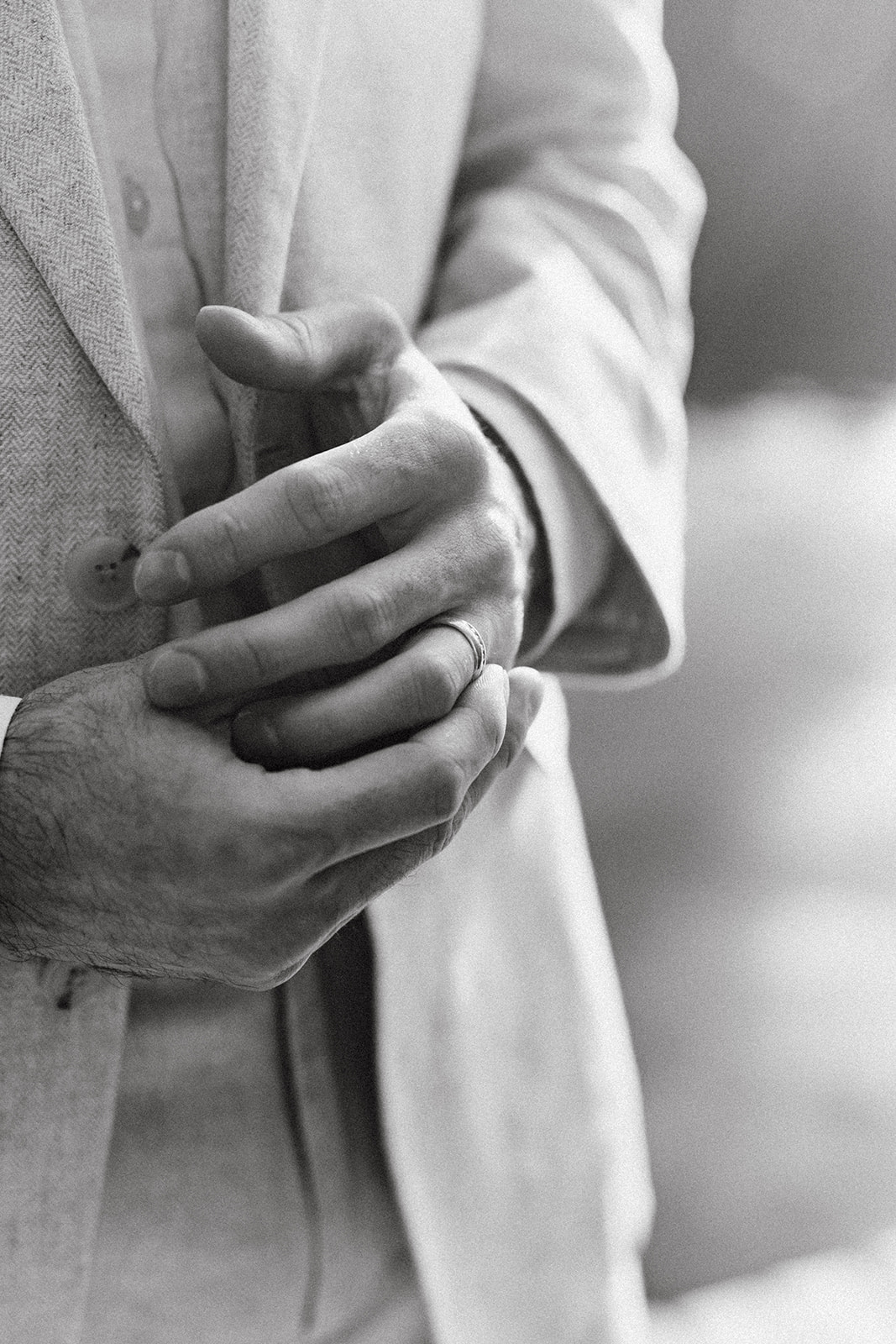 groom twists his new wedding band on as he gets used to the feeling on his finger