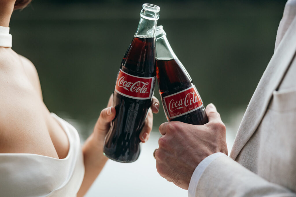 couple share cokes and laughs on the edge of the dock as their Georgia elopement day winds down