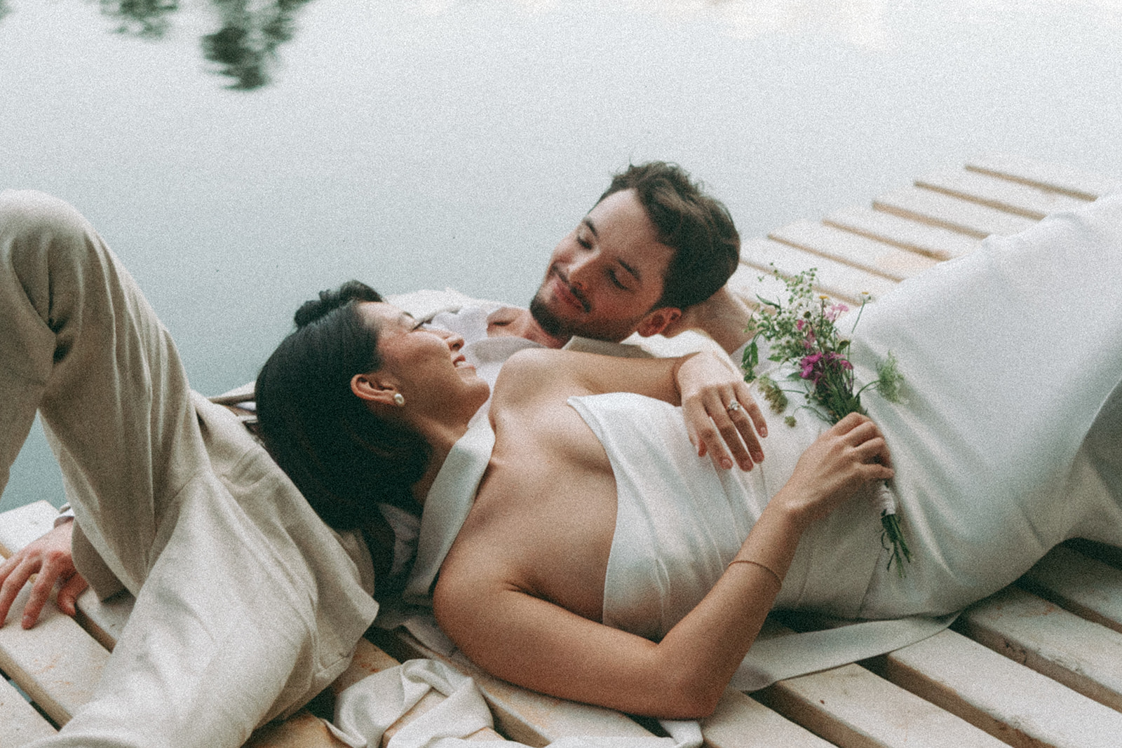 beautiful couple lay on the dock together after their lakeside dahlonega elopement
