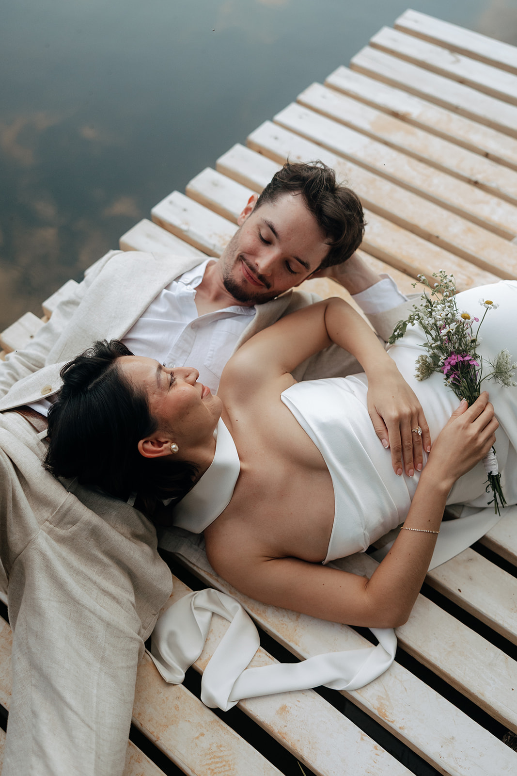 couple lie on the dock together on their unique lakeside dahlonega elopement